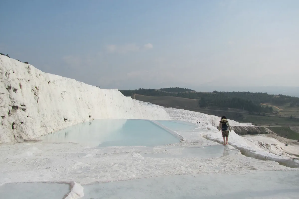 Pamukkale'de travertenler üzerinde çıplak ayakla yürüyen ziyaretçi